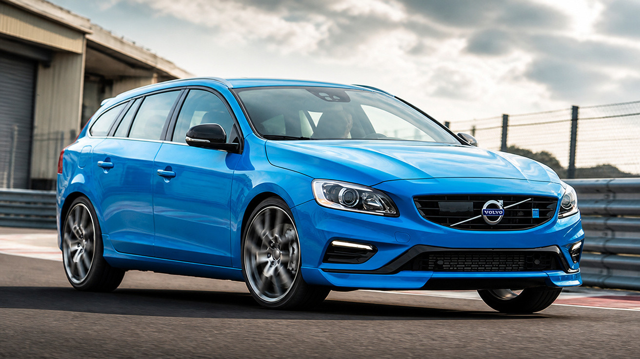 Blauer Volvo Kombi fährt auf Rennstrecke bei bewölktem Himmel, sportliches Design und breite Reifen.