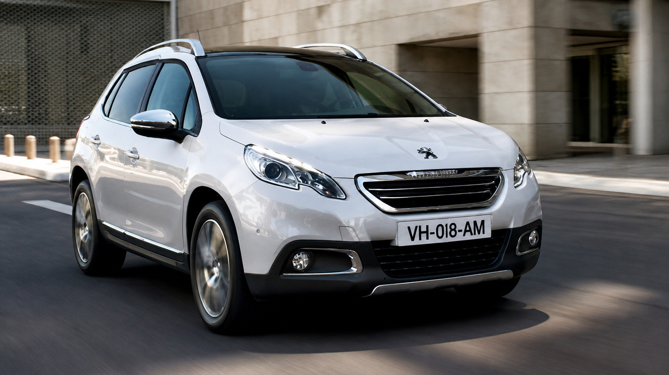 Weisser Peugeot SUV fährt auf städtischer Strasse vor Gebäuden im Sonnenlicht.