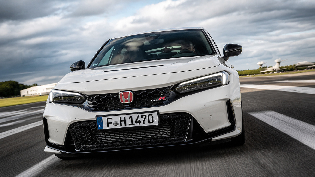 Weisser Honda Civic Type R fährt auf Strasse unter bewölktem Himmel, deutsche Nummernschilder sichtbar.